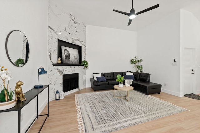 609 Clearwater Trl, Round Rock, TX 78664 - living room featuring wood finished floors, a premium fireplace, a ceiling fan, and baseboards