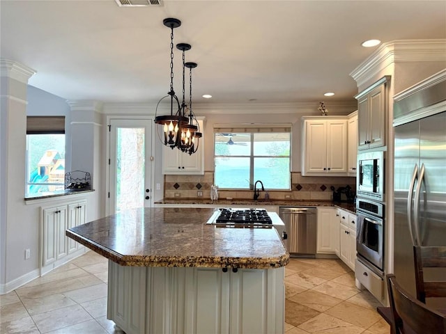 804 Lakewood Hills Ter, Austin, TX 78732 - kitchen with built in appliances, decorative backsplash, a kitchen island, light tile patterned flooring, and pendant lighting