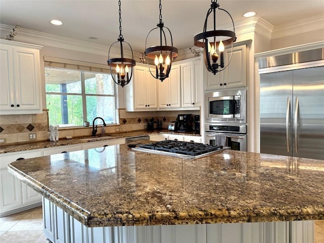 804 Lakewood Hills Ter, Austin, TX 78732 - kitchen with built in appliances, a kitchen island, a chandelier, backsplash, and white cabinetry