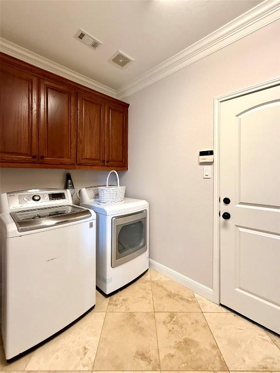 804 Lakewood Hills Ter, Austin, TX 78732 - laundry area featuring ornamental molding, cabinet space, washer and clothes dryer, and light tile patterned floors