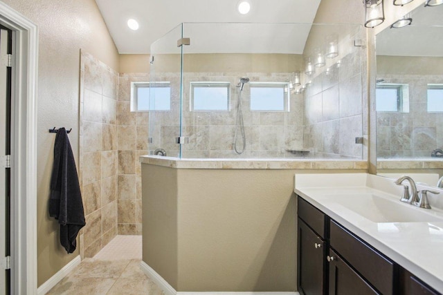 bathroom featuring a walk in shower and vanity