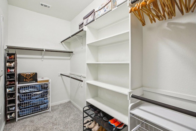 walk in closet featuring visible vents and carpet floors