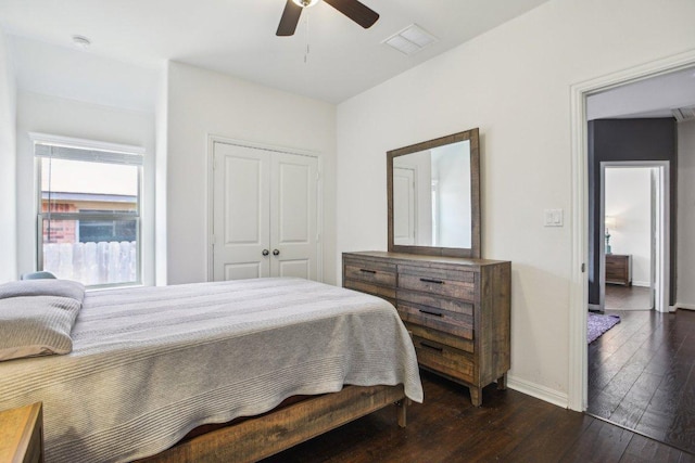 bedroom with visible vents, dark wood-style floors, a closet, baseboards, and a ceiling fan