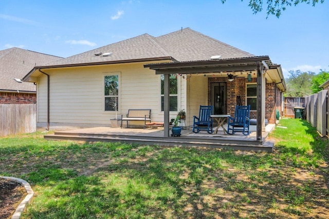 rear view of property featuring a deck, a yard, and a fenced backyard