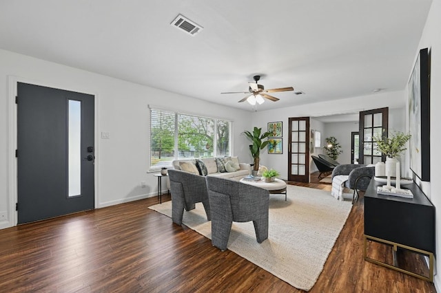 living area with ceiling fan, baseboards, visible vents, and wood finished floors