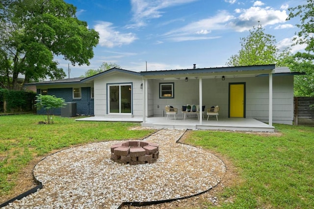 rear view of house with a patio area, central AC, fence, an outdoor fire pit, and a yard
