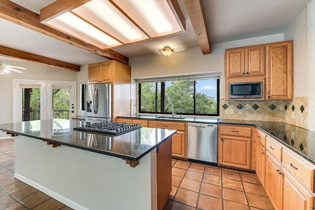 kitchen with light tile patterned floors, beamed ceiling, a sink, stainless steel appliances, and backsplash