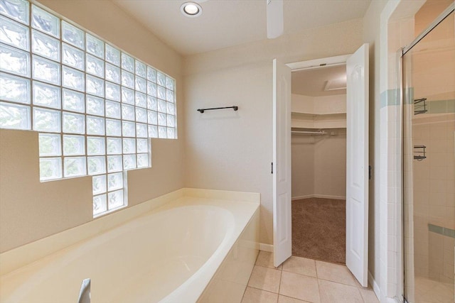 full bathroom featuring recessed lighting, tile patterned flooring, a spacious closet, a stall shower, and a garden tub