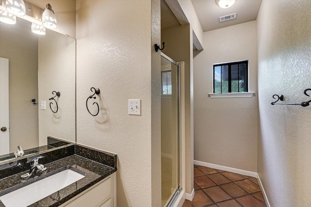 full bathroom featuring a shower stall, vanity, visible vents, baseboards, and tile patterned flooring