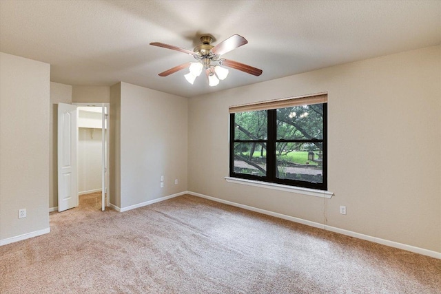 unfurnished bedroom with a ceiling fan, light carpet, and baseboards