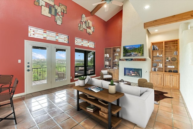 tiled living room with recessed lighting, high vaulted ceiling, a glass covered fireplace, a ceiling fan, and french doors