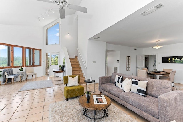 1313 Spyglass Dr, Austin, TX 78746 - living room featuring light tile patterned floors, a ceiling fan, a high ceiling, visible vents, and stairs
