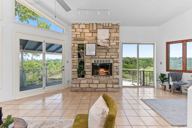 1313 Spyglass Dr, Austin, TX 78746 - unfurnished living room with tile patterned flooring, a fireplace, ceiling fan, and plenty of natural light