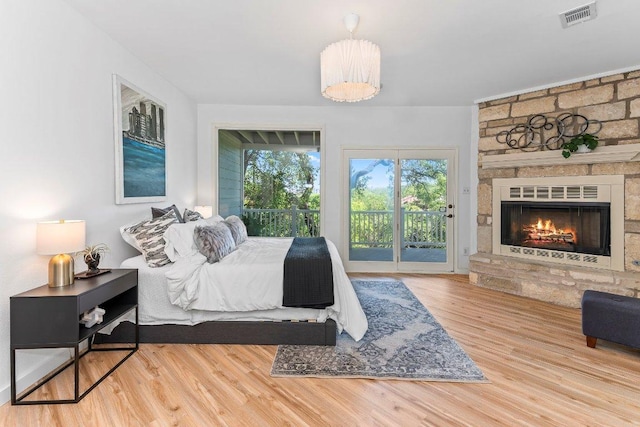 1313 Spyglass Dr, Austin, TX 78746 - bedroom featuring a fireplace, wood finished floors, visible vents, and access to exterior