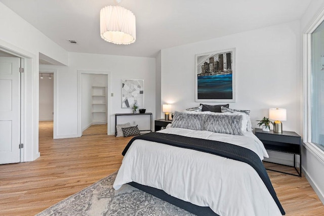 1313 Spyglass Dr, Austin, TX 78746 - bedroom featuring light wood-type flooring, baseboards, and visible vents