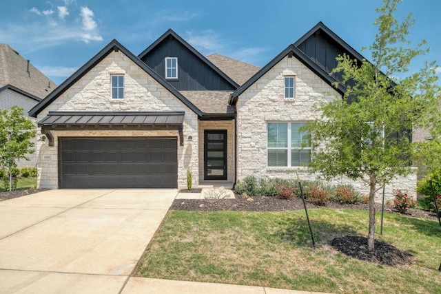 craftsman house featuring a front lawn, driveway, stone siding, and board and batten siding