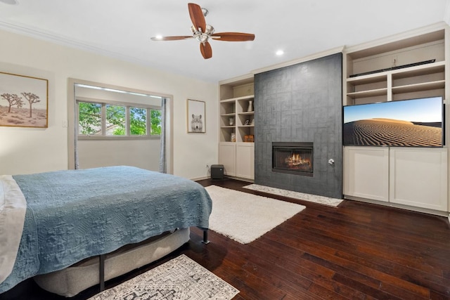 9 Swiftwater Trl, The Hills, TX 78738 - bedroom featuring dark wood-type flooring, a tiled fireplace, recessed lighting, a ceiling fan, and ornamental molding
