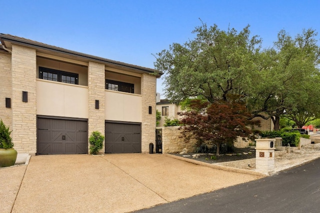 9 Swiftwater Trl, The Hills, TX 78738 - view of front facade with stone siding, a garage, driveway, and a balcony