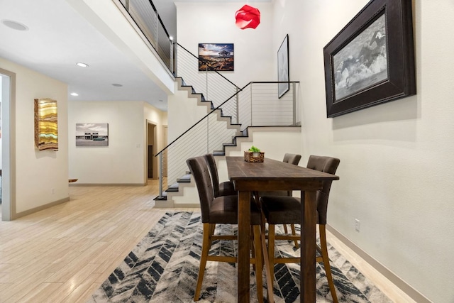 9 Swiftwater Trl, The Hills, TX 78738 - dining area with stairs, light wood-style floors, recessed lighting, and a towering ceiling