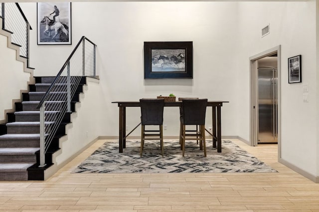 9 Swiftwater Trl, The Hills, TX 78738 - dining space featuring light wood-type flooring, stairway, and a high ceiling