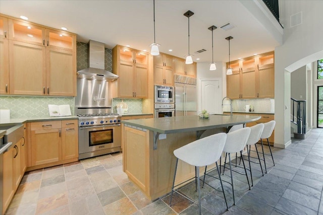 5412 Moon Shadow Dr, Austin, TX 78735 - kitchen with a kitchen island with sink, a sink, stone tile flooring, built in appliances, and wall chimney range hood