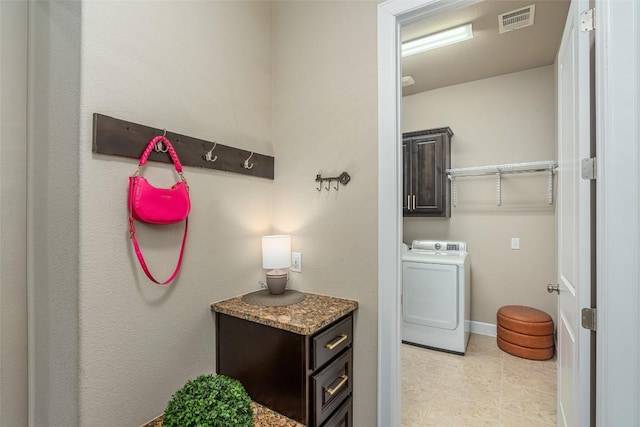 2421 Carretera Dr, Leander, TX 78641 - laundry room featuring washer / clothes dryer, cabinet space, light tile patterned floors, and baseboards
