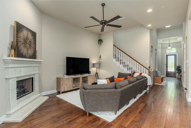 2421 Carretera Dr, Leander, TX 78641 - living area featuring dark wood-type flooring, stairs, recessed lighting, a ceiling fan, and a fireplace with raised hearth