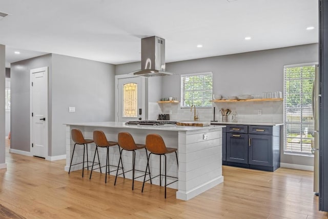 1712 Alleghany Dr, Austin, TX 78741 - kitchen featuring island range hood, open shelves, light wood-style floors, baseboards, and recessed lighting