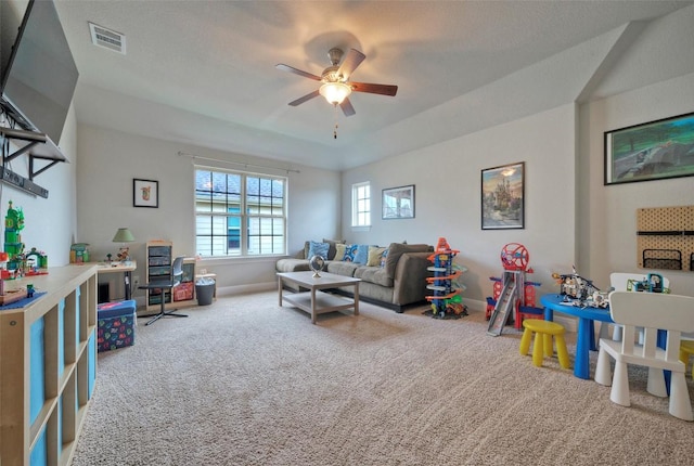 carpeted living area featuring visible vents, ceiling fan, and baseboards