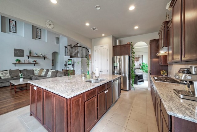 kitchen featuring ventilation hood, visible vents, arched walkways, and appliances with stainless steel finishes