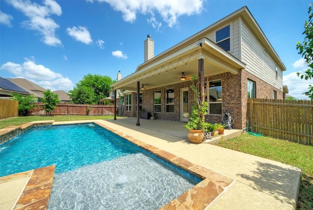 rear view of property featuring a fenced in pool, a patio area, a ceiling fan, brick siding, and a fenced backyard