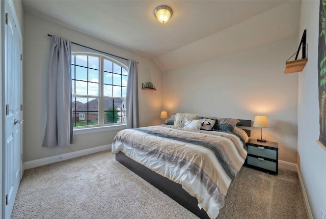 bedroom with carpet flooring, vaulted ceiling, and baseboards
