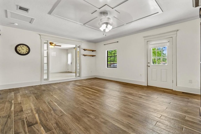 unfurnished room featuring a ceiling fan, attic access, visible vents, baseboards, and hardwood / wood-style floors