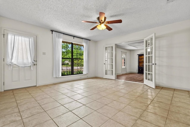 spare room with french doors, a textured ceiling, ceiling fan, and light tile patterned flooring