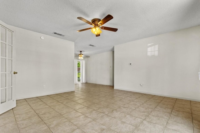 unfurnished room with a ceiling fan, a textured ceiling, visible vents, and baseboards