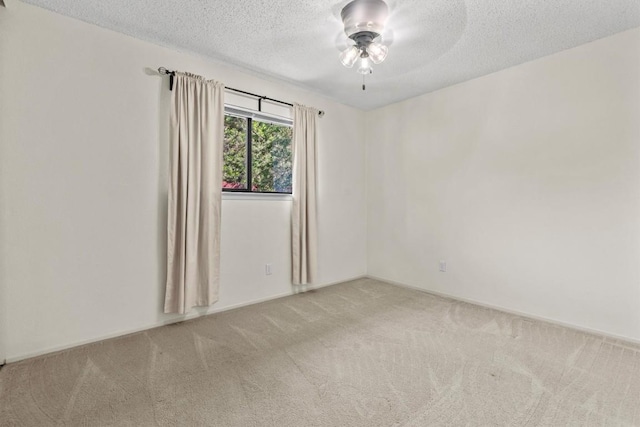 empty room featuring carpet floors, a ceiling fan, and a textured ceiling
