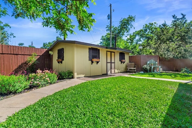 view of front of house featuring an outdoor structure, a fenced backyard, and a front lawn