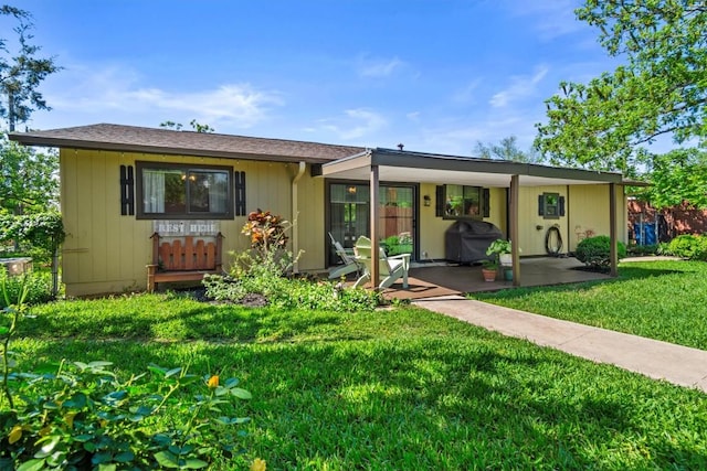back of house with a lawn and a patio area