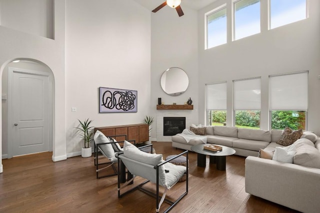 18617 Rio Chama Ln, Austin, TX 78738 - living room featuring a towering ceiling, arched walkways, ceiling fan, baseboards, and a glass covered fireplace