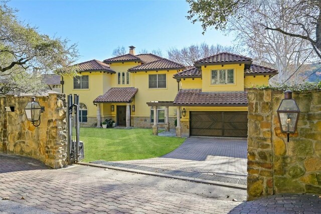3111 Ski Shores Ter, Austin, TX 78730 - mediterranean / spanish-style house featuring a garage, a tile roof, decorative driveway, and stucco siding