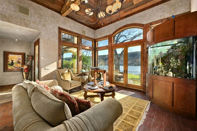 3111 Ski Shores Ter, Austin, TX 78730 - living room featuring a chandelier, beam ceiling, healthy amount of natural light, a water view, and hardwood / wood-style floors