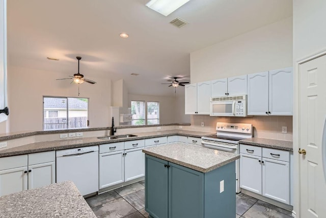 kitchen featuring white appliances, white cabinets, backsplash, ceiling fan, and a sink