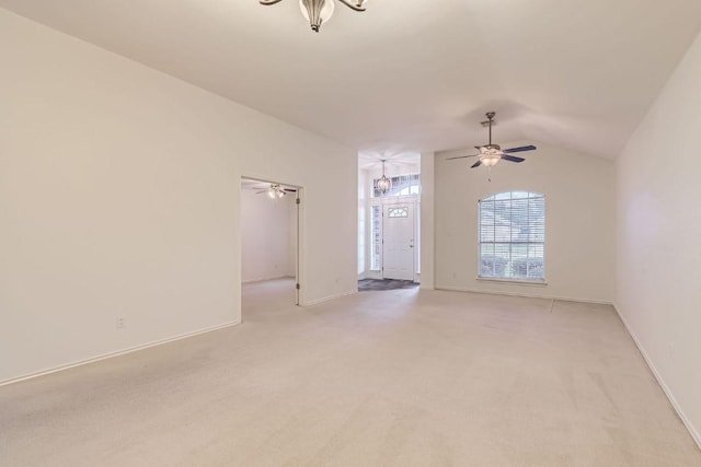 empty room with ceiling fan, vaulted ceiling, light colored carpet, and baseboards
