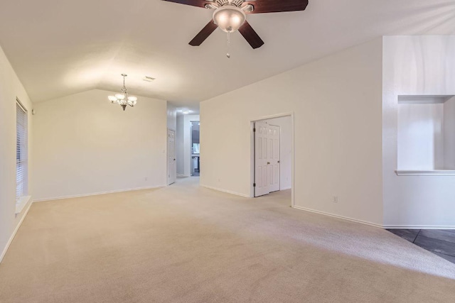 empty room featuring lofted ceiling, baseboards, ceiling fan with notable chandelier, and light carpet