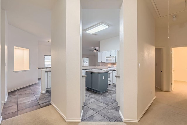 corridor with baseboards, light tile patterned floors, and attic access
