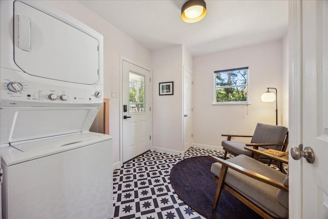 washroom with stacked washer / dryer, plenty of natural light, baseboards, and light floors