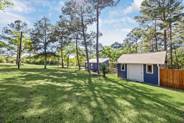 view of yard with an outdoor structure and fence