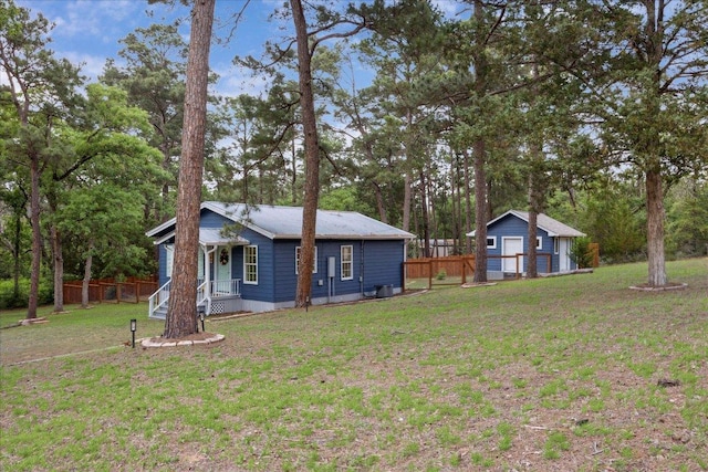 view of yard with fence, an outdoor structure, and a porch
