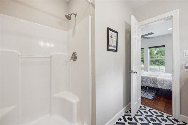 bathroom featuring baseboards, a ceiling fan, and a shower stall
