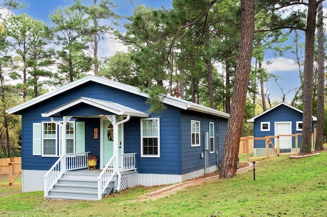 bungalow featuring a front lawn and fence